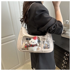 Detail of hobo shoulder bag with a transparent front pocket showing plush dog charms
