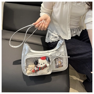 Detail view of silver Y2K shoulder bag featuring clear window and plush character