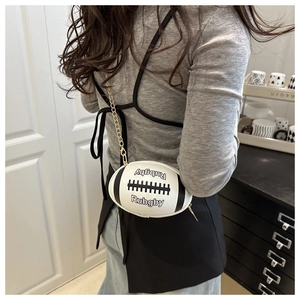 Close-up of a rugby-shaped crossbody bag with gold chain and contrast stitching