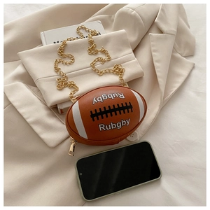 Detail der rugbyförmigen Umhängetasche mit brauner Lychee-Struktur und Goldkette