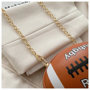 Detail of the golden chain strap and textured rugby-shaped leather crossbody bag