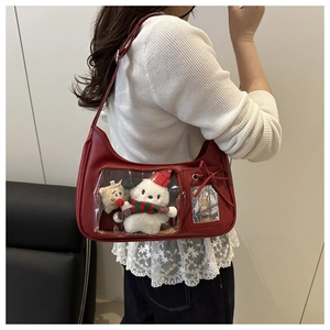 Detail of red PU hobo bag with clear window featuring a plush white dog toy