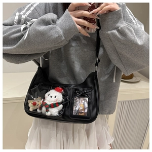 Detail of black crescent shoulder bag with transparent PVC window for plush toys and bows