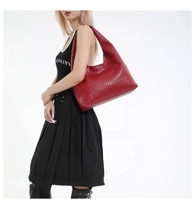 Close-up of a large red woven leather shoulder bag with a half-moon Hobo shape structure