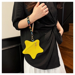 Detail of a bright yellow star-shaped leather coin purse with a black LOVE strap