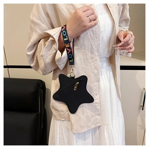 Close-up of star-shaped coin purse with LOVE woven wrist strap and black leather texture