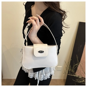 Détail d'un sac sous le bras en cuir PU blanc avec logo métallique argenté chic