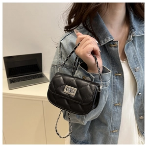 Detail of black quilted leather mini flap bag with silver chain and twist-lock buckle