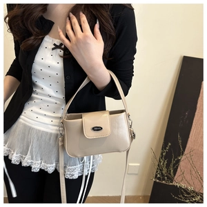 Detail of beige oil wax leather crossbody bag featuring silver JWHN logo and top handle