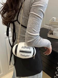 Fashionable rugby shaped crossbody bag with black and white contrast and gold chain strap