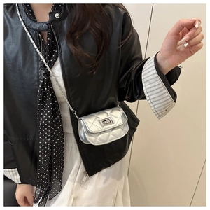 Close-up of a silver quilted mini crossbody bag with metal twist lock and chain strap