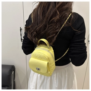 Detailansicht eines gelben Mini-Rucksacks mit Steppnähten und Kettenriemen in der Rückansicht