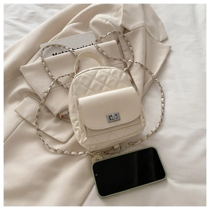 Detail of quilted mini backpack with chain strap and phone for size comparison