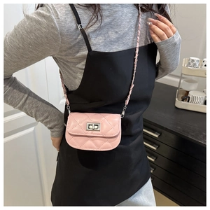 Quilted pink mini crossbody bag with silver twist lock and chain strap on female model