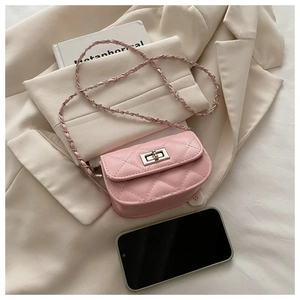 Detail of pink quilted mini crossbody bag with silver twist lock on beige blazer