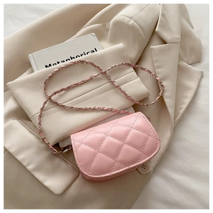 Close-up of pink quilted crossbody bag with leather-woven chain on blazer
