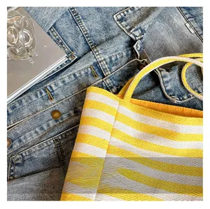 Close-up of durable yellow and white striped woven canvas fabric on a large tote bag