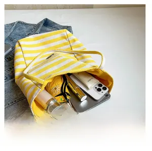 Interior view of striped canvas tote showing large capacity for umbrella and phone