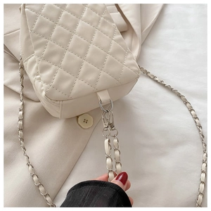 Detailed macro view of beige quilted PU leather crossbody bag with silver chain strap