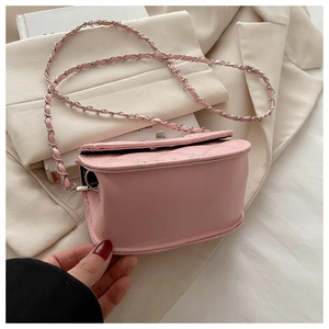 Close-up of pink quilted crossbody bag with metal chain strap and elegant rhombus pattern
