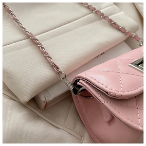 Close-up of pink quilted leather shoulder bag with silver chain and metal twist lock
