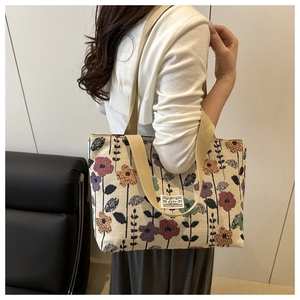 Vista dettagliata della borsa tote in tela retrò con stampa floreale e logo cucito