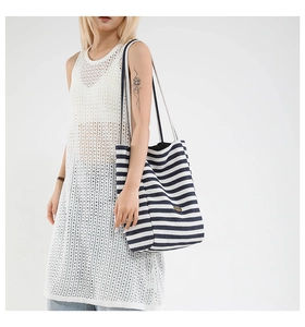 Close-up of blue striped canvas tote bag showing thick texture and metal logo plate