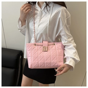 Close-up of pink quilted leather tote featuring gold metal chain and dual-letter clasp