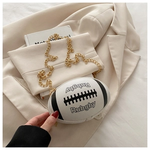 Detail shot of a white rugby-shaped crossbody bag with gold chain strap on a blazer