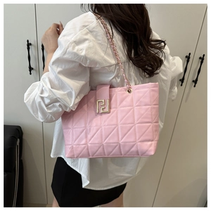 Detail of pink quilted tote bag with golden metal buckle and chain shoulder strap