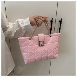 Macro shot of pink quilted faux leather texture with elegant golden metal square buckle