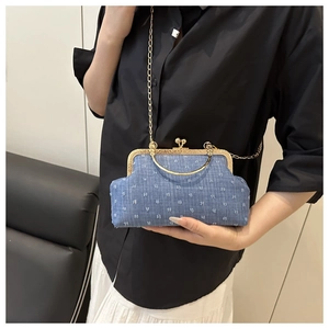 Detail of blue jacquard small square bag with gold metal frame and chain strap
