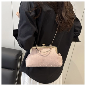 Detailed view of pink textured fabric evening bag with gold handle and chain strap