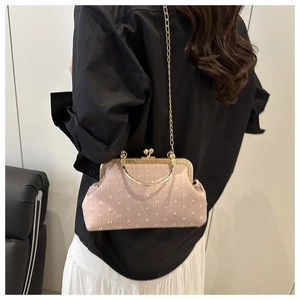 Détail du sac en tissu brodé rose avec poignée en métal doré et bandoulière chaîne