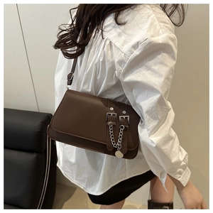 Detail of dark brown leather handbag with silver buckles and a decorative metal chain