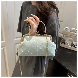 Détail du sac à fermoir baiser bleu menthe avec texture à pois 3D et poignée dorée chic