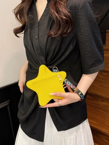 Portamonete a stella giallo in pelle con cinturino LOVE tenuto da una modella