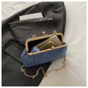 Dettaglio della borsa in denim blu con spazio interno per telefono e cosmetici
