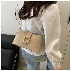 Detailed back view of a beige minimalist underarm bag with gold horseshoe buckle
