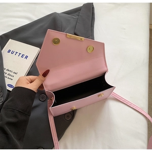 Detail of pink envelope flap bag showing black interior lining and gold hardware