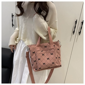 Vue détaillée du sac cabas en velours côtelé rose avec motif nœud et texture matelassée