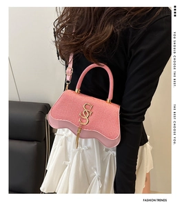 Pink crossbody bag featuring woven texture and unique wavy bottom edge with tassel