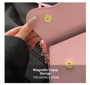 Close-up of pink leather saddle bag with gold magnetic buckle and fine stitching detail