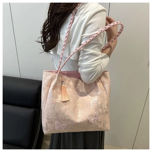 Close-up of pink tote bag featuring embroidery butterfly and woven handle detail