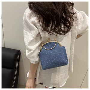 Détail du sac vintage en denim bleu à pois blancs avec poignée en métal doré