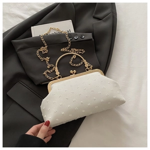 Dettaglio borsa da sera bianca con texture 3D, manico dorato e tracolla a catena