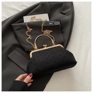 Dettaglio della chiusura a scatto e manico dorato su borsa vintage nera a pois