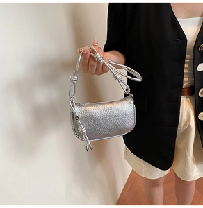 Detail der silbernen Satteltasche mit geknotetem Riemen und elegantem Reißverschluss
