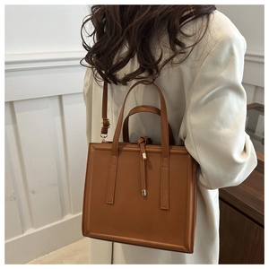 Classic brown square crossbody bag with knot detail shown on a model's shoulder