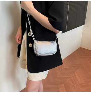 Detail of silver textured mini crossbody bag with unique knot shoulder strap design